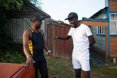 İki zenci şaka ve bir köy evinin arka plan üzerinde iyi eğlenceler