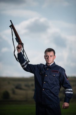 Güzel genç polis memuru üniformalı, kırsal manzara arka plan üzerinde elinde silahla
