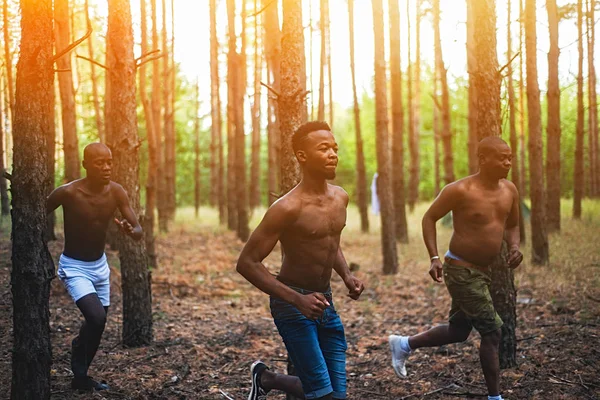 Homens afro-americanos a correr na floresta ao pôr-do-sol. Atletas jogs — Fotografia de Stock
