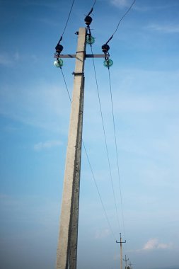Yüksek gerilim elektrik direkleri mavi bulutlu gökyüzü arka plan üzerinde
