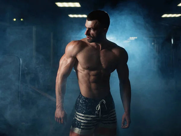 Güçlü fitness adam gösterir onun atletik vücut salonunda spor. Sağlıklı bir yaşam tarzı kavramı