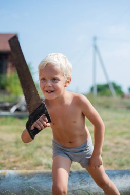 Erkek evlat olmazsa bir t-shirt elinde bir testere ile portresi