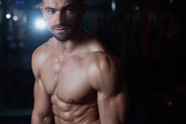 Jimnastik salonu kas vücut ile acımasız atletik bir adam portresi. Sağlık ve fitness kavramı