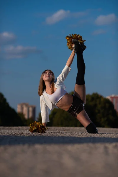 ポンポン空を背景に屋外ダンスで美しいチアリーダーの女の子 — ストック写真