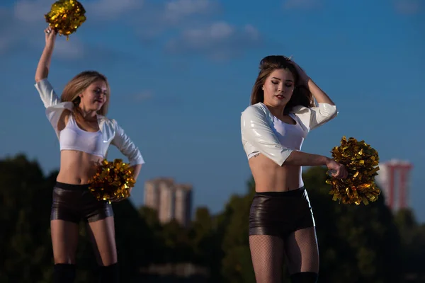 Twee Meisjes Cheerleaders Met Pompons Dansen Buitenshuis Hemel Achtergrond — Stockfoto