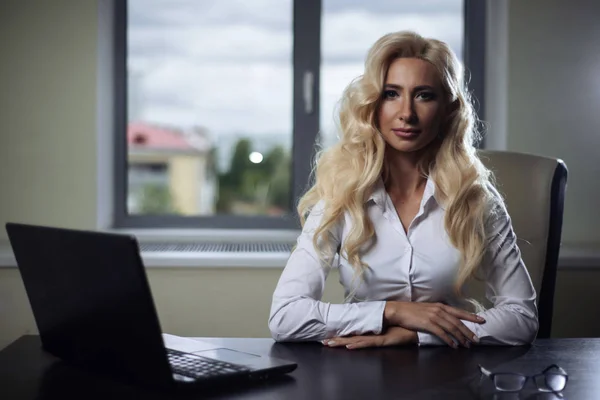 attractive woman boss sitting at a table in the office