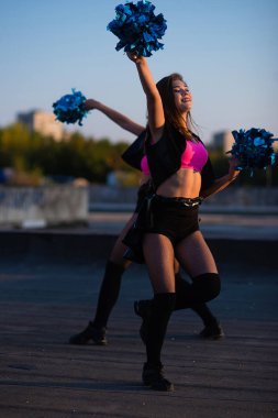 Şehir manzarası karşı gün batımında çatıda dans amigo kızlar