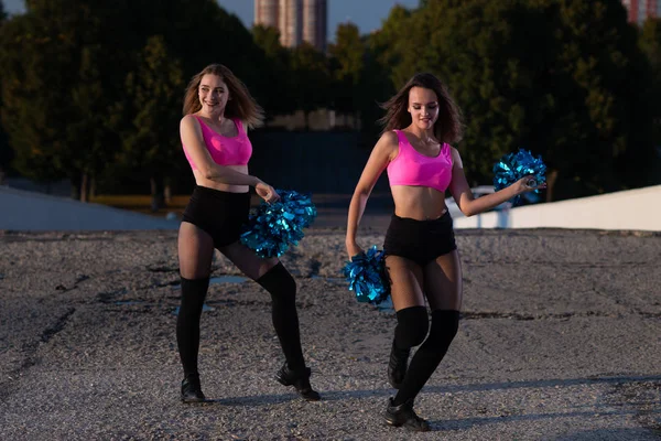 Twee Meisjes Cheerleaders Met Pompons Dansen Buitenshuis Hemel Achtergrond — Stockfoto