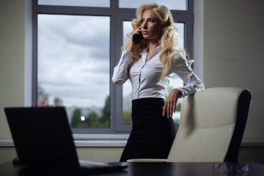 pencerenin yakınındaki telefonda konuşurken ofiste çekici çalışan