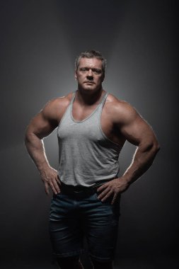 Güçlü kas vücut geliştirmeci siyah bir arka plan üzerinde poz. Güç ve duman sağlık kavramı