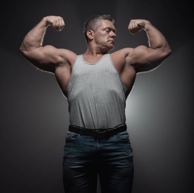 Güçlü kas vücut geliştirmeci siyah bir arka plan üzerinde poz. Güç ve duman sağlık kavramı
