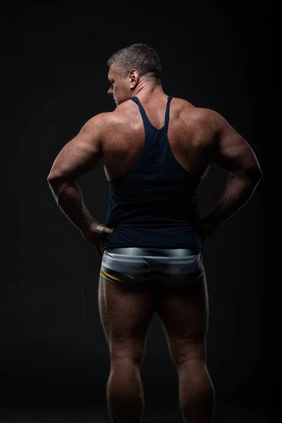 Krachtig Gespierde Bodybuilder Poseren Een Zwarte Achtergrond Het Concept Van — Stockfoto
