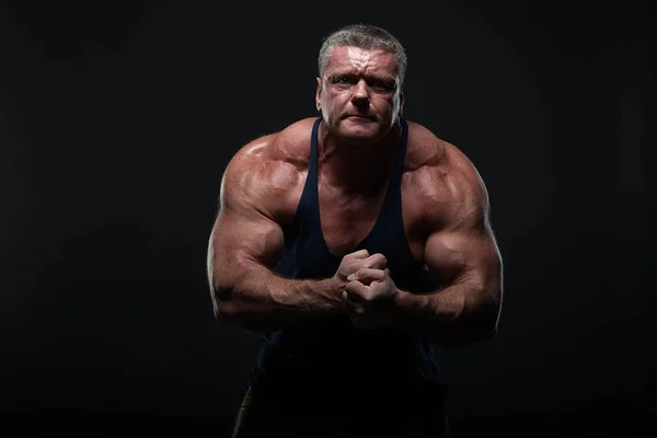 Een Krachtig Gespierde Man Toont Biceps Een Zwarte Achtergrond Kracht — Stockfoto