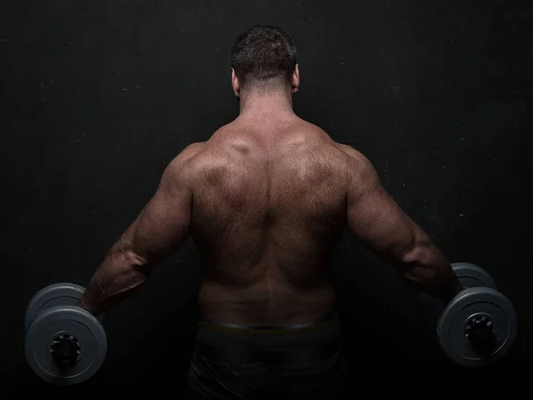 Poderoso Atleta Muscular Treina Com Halteres Perto Parede Grunge Preto — Fotografia de Stock
