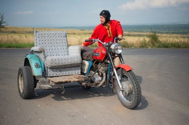 Rusya, Syzran - 2 Eylül 2018: Genç bir adam güzel bir kırsal manzara arka planı yolda kırık bir motosiklet yol