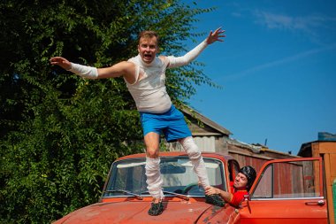 Rusya, Syzran - 2 Eylül 2018: Genç bir adam araba üzerinde duran ve having fun bandaj