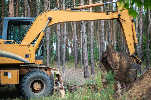 РОССИЯ, СИЗРАН - 2 СЕНТЯБРЯ 2018 г.: Экскаватор проводит земляные работы, копая землю ведром
