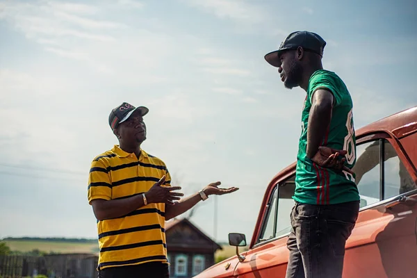 Rusya, Syzran - 2 Eylül 2018: İki zenci iş konularında car yakınındaki gökyüzü artalanları üzerinde tartışmak.