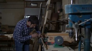 Adam marangoz ahşap tahta mengeneye giderir.