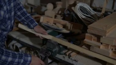 Adam marangoz ahşap tahta mengeneye giderir.