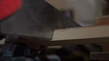 yetişkin adam atölye mengeneye sabitlenmiş bir ahşap tahta testereleri