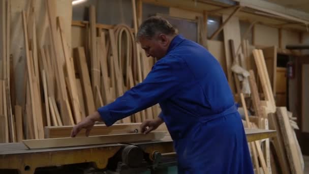 Carpenter at work at his workshop, wood processing on a woodworking machine — Stock Video