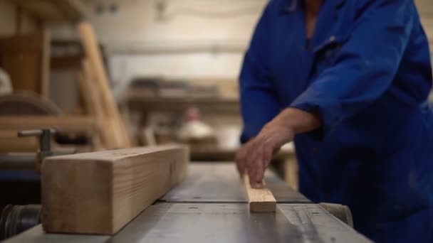 Carpintero en el trabajo en su taller, procesamiento de madera en una máquina de carpintería — Vídeos de Stock