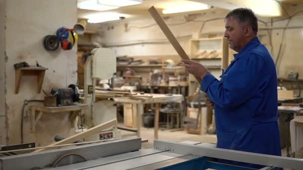 Stolarz w pracy o swoim warsztacie, drewna, przetwarzania na maszynie do obróbki drewna — Wideo stockowe