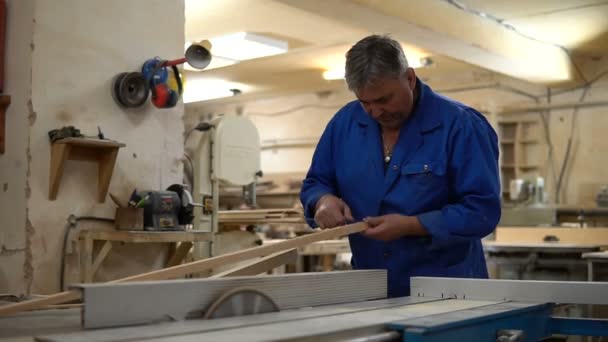 Carpenter at work at his workshop, wood processing on a woodworking machine — Stock Video