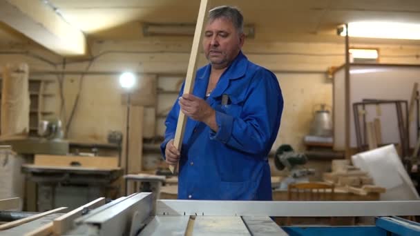 Falegname al lavoro nella sua officina, lavorazione del legno su una macchina per la lavorazione del legno — Video Stock