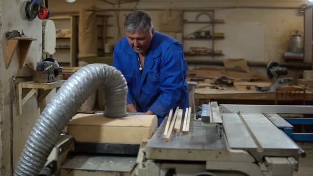 Timmerman aan het werk in zijn werkplaats, hout verwerken op een houtbewerking machine — Stockvideo