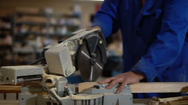 Elektrische zaag voor het zagen van planken, werknemer zagen een houten bord in de werkplaats — Stockvideo