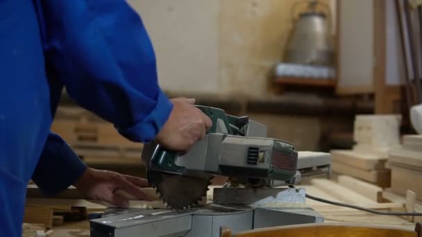 Sierra eléctrica para aserrar tablas, el trabajador sierra una tabla de madera en el taller — Vídeos de Stock