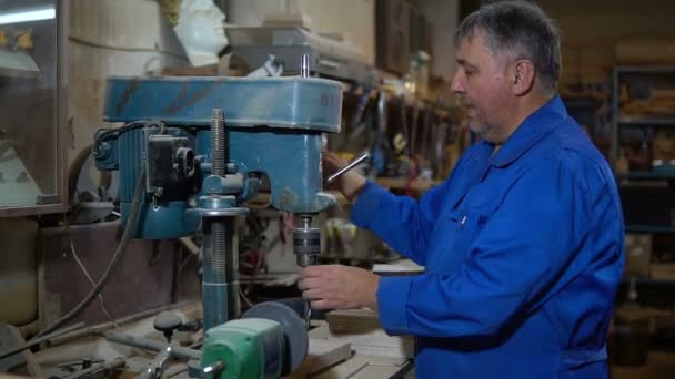 L'employé perce l'article dans l'atelier à l'aide d'une presse de forage — Video