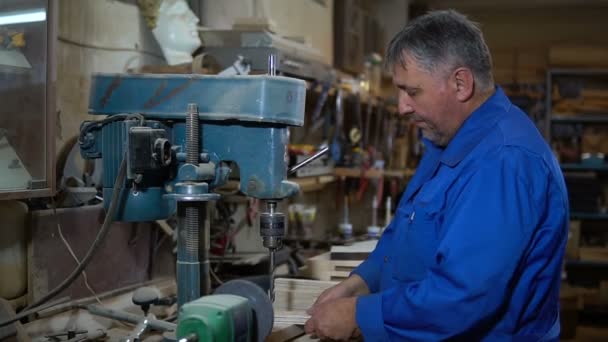 Dipendente trapana l'elemento in officina con l'aiuto di una pressa di perforazione — Video Stock