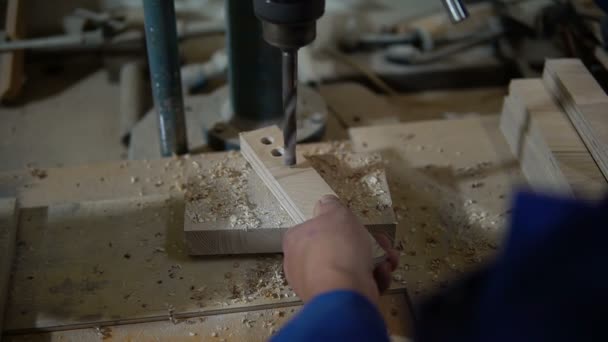 Сотрудник сверлит деталь в мастерской с помощью буровой машины — стоковое видео