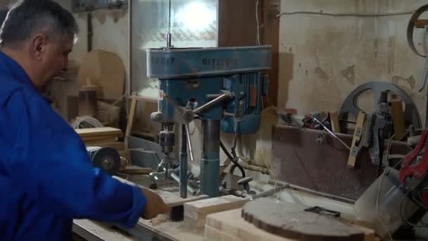 Dipendente trapana l'elemento in officina con l'aiuto di una pressa di perforazione — Video Stock