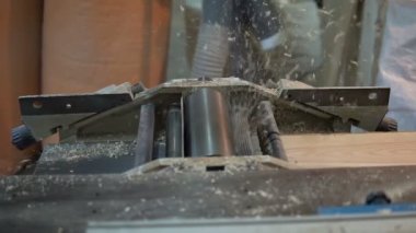 Bir ağaç işleme makinesi üzerinde çalışan bir marangoz. Bileme ve ahşap işleme