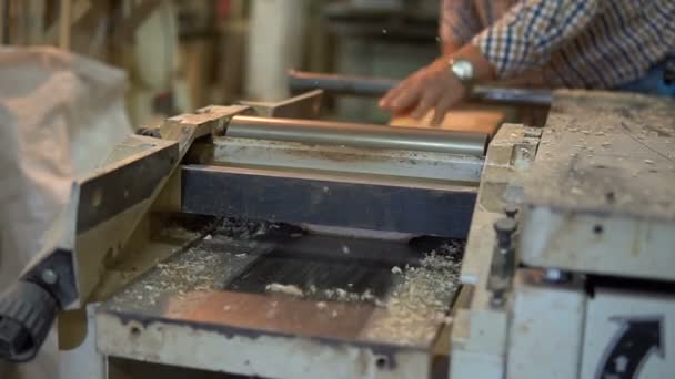 Carpenter working on a woodworking machine. Grinding and processing of wood — Stock Video