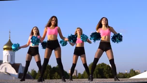 Cheerleader meisjes met pompoms dansen buitenshuis op sky backround — Stockvideo