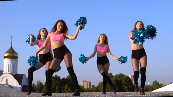 Cheerleader tjejer med pompoms dansa utomhus på sky bakrund — Stockvideo