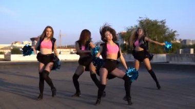 Çatıda günbatımında dans amigo kızlar