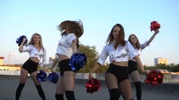 Cheerleader meisjes dansen op het dak bij zonsondergang — Stockvideo