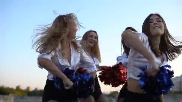 Cheerleader meisjes dansen op het dak bij zonsondergang — Stockvideo
