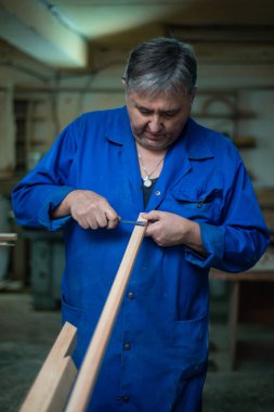 Marangoz atölyesini bir adam sonra işte ölçümleri yapar