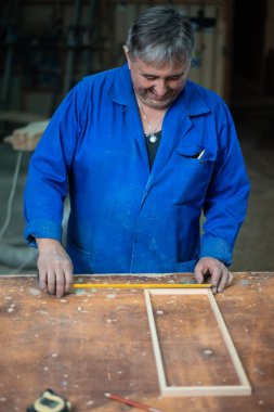 Tutkal ve farklı araçlar ile atölyesinde marangozluk masada ahşap çerçeve montaj