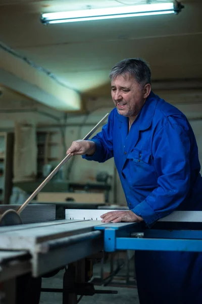 Carpenter at work at his workshop, wood processing on a woodworking machine in worshop