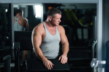 Spor salonunda büyük atletik adam trenler. Egzersiz sonrası dinlenme