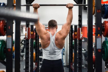 Büyük kas adam onun omuz ile bir halter salonunda eğitiyor. Sağlık ve fitness kavramı