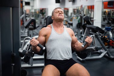 Spor salonunda büyük atletik adam trenler. Eğitim pazı